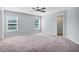 Spacious carpeted bedroom with a ceiling fan and walk in closet at 648 Lorient Dr, Eagle Lake, FL 33839
