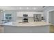 Open kitchen with stainless steel appliances and an island with a sink at 648 Lorient Dr, Eagle Lake, FL 33839