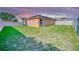 A spacious backyard with a patio area, lush green grass, and a white fence for privacy at 713 Overlook Grove Dr, Winter Haven, FL 33884