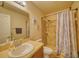 Well-maintained bathroom with a single sink, toilet, and tiled walk-in shower with decorative curtain at 713 Overlook Grove Dr, Winter Haven, FL 33884