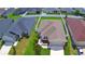 Aerial view of a single-story home with fenced yard, surrounded by lush green lawns at 879 Orleans Dr, Eagle Lake, FL 33839