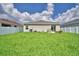 Spacious backyard offering a large grassy area, perfect for outdoor activities and relaxation, sunny weather at 879 Orleans Dr, Eagle Lake, FL 33839