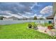 Well-maintained backyard featuring a lush green lawn, a white fence, and vibrant flower pots at 879 Orleans Dr, Eagle Lake, FL 33839