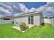 Backyard featuring a patio with seating, accented by colorful potted plants and a lush lawn, sunny at 879 Orleans Dr, Eagle Lake, FL 33839
