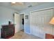 Bedroom featuring a dresser, bi-fold closet doors and a view into an adjoining room or walk-in closet at 879 Orleans Dr, Eagle Lake, FL 33839