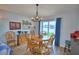 Cozy dining area featuring a round wooden table, chandelier, and sliding glass doors to the backyard at 879 Orleans Dr, Eagle Lake, FL 33839