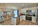 Well-lit kitchen with stainless steel appliances, modern cabinetry, and an adjacent dining area at 879 Orleans Dr, Eagle Lake, FL 33839
