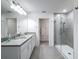 Modern bathroom with double sinks, quartz counters, framed mirrors and glass shower at 912 Scrub Oak Hammock Rd, Davenport, FL 33837