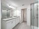 Modern bathroom with double sinks, quartz counters, framed mirrors and glass shower at 912 Scrub Oak Hammock Rd, Davenport, FL 33837