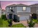 Charming two-story home showcasing a well-maintained yard and two car garage at 912 Scrub Oak Hammock Rd, Davenport, FL 33837