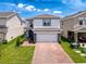 Well-maintained two-story home with a two-car garage, brick driveway, and nicely landscaped front yard at 912 Scrub Oak Hammock Rd, Davenport, FL 33837