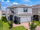 Beautiful two-story home featuring a well-manicured lawn, brick driveway, and attached two-car garage at 912 Scrub Oak Hammock Rd, Davenport, FL 33837