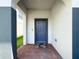 Inviting front entrance with a stylish blue door, brick pathway, and neutral-colored exterior at 912 Scrub Oak Hammock Rd, Davenport, FL 33837