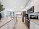 Bright kitchen features white cabinets, stainless steel appliances, granite countertops, and tile flooring at 912 Scrub Oak Hammock Rd, Davenport, FL 33837