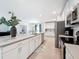 Bright kitchen features white cabinets, stainless steel appliances, granite countertops, and tile flooring at 912 Scrub Oak Hammock Rd, Davenport, FL 33837