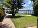 Waterfront backyard featuring lawn, trees, and a covered dock with fence at 9402 Cat Track Trl, Lake Wales, FL 33898