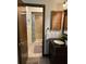 Bathroom with a vanity featuring a black countertop, and a walk-in shower with patterned tile at 9402 Cat Track Trl, Lake Wales, FL 33898