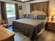 Warm, inviting bedroom with plush bedding, lamps, and a wooden floor at 9402 Cat Track Trl, Lake Wales, FL 33898