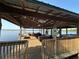 Large covered dock on the water featuring comfortable lounge areas, a grill, and plenty of space for entertaining at 9402 Cat Track Trl, Lake Wales, FL 33898