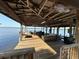 Expansive covered dock with outdoor kitchen and seating area, perfect for lakeside entertaining at 9402 Cat Track Trl, Lake Wales, FL 33898