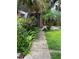 A stone path leads to the front door, surrounded by lush tropical plants at 9402 Cat Track Trl, Lake Wales, FL 33898