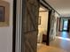Hallway with rustic sliding barn door with white trim walls and tile floor at 9402 Cat Track Trl, Lake Wales, FL 33898