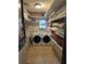 Bright laundry room with modern washer and dryer and ample storage shelves at 9402 Cat Track Trl, Lake Wales, FL 33898