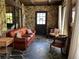 Cozy living room with stone walls, unique flooring, comfortable seating, and a decorative mirror at 9402 Cat Track Trl, Lake Wales, FL 33898