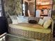 Charming living room with a comfortable daybed and a stone accent wall at 9402 Cat Track Trl, Lake Wales, FL 33898