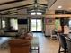 Bright and open living room with stone accents, dining area, modern kitchen, and backyard views at 9402 Cat Track Trl, Lake Wales, FL 33898