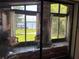 Stunning view from the cozy living room through large windows showcasing a manicured lawn and lakefront property at 9402 Cat Track Trl, Lake Wales, FL 33898