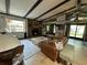 Spacious living room featuring a stone fireplace, beamed ceilings, and plenty of natural light at 9402 Cat Track Trl, Lake Wales, FL 33898