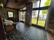 Charming sun room featuring stone walls, slate floors, and views of the lake and backyard at 9402 Cat Track Trl, Lake Wales, FL 33898