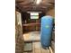 Interior view of well room, featuring a WELL-X-TROL water tank and wooden shelving at 9402 Cat Track Trl, Lake Wales, FL 33898