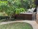 Charming backyard featuring a brick walkway, shed, mature tree, and grassy lawn at 9402 Cat Track Trl, Lake Wales, FL 33898
