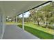 The covered back porch provides scenic views of the lush backyard and tranquil lake at 1042 Golden Bough Rd, Lake Wales, FL 33898