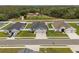 Aerial view of single-story home featuring a gray roof, two-car garage, and well-manicured lawn at 1081 Sandpiper Loop, Winter Haven, FL 33881