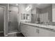 Elegant bathroom with double vanity, granite countertops, and a tiled shower at 1081 Sandpiper Loop, Winter Haven, FL 33881