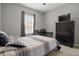This bedroom includes a large window for natural light, a dresser, and modern decor at 1081 Sandpiper Loop, Winter Haven, FL 33881