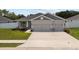Charming one-story home featuring gray stucco, a two-car garage, and well-kept front yard at 1081 Sandpiper Loop, Winter Haven, FL 33881