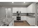 Well-lit kitchen featuring white cabinets, stainless steel appliances, and granite countertops at 1081 Sandpiper Loop, Winter Haven, FL 33881