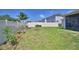 Private fenced backyard with a lush lawn and garden beds, perfect for outdoor enjoyment at 1100 Sugarwood St, Davenport, FL 33837