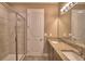 Bathroom featuring double vanity, glass shower, tiled floors, and neutral colors at 1100 Sugarwood St, Davenport, FL 33837