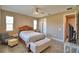 Bright bedroom featuring a ceiling fan, warm neutral colors, and wood-look tile flooring at 1100 Sugarwood St, Davenport, FL 33837