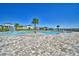 The community pool area has a splashpad feature, and is surrounded by palm trees and seating at 1100 Sugarwood St, Davenport, FL 33837