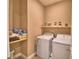 Functional laundry room with washer, dryer, and shelving for storage at 1100 Sugarwood St, Davenport, FL 33837
