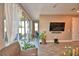 Bright living room with tile flooring, a large TV, and sliding doors to the screened patio at 1100 Sugarwood St, Davenport, FL 33837