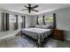 Cozy bedroom with a ceiling fan, wood-look floors, and three windows at 1140 W Seminole Trl, Bartow, FL 33830