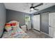 Bedroom with dark gray walls, ceiling fan, light, a window, and dresser at 1140 W Seminole Trl, Bartow, FL 33830