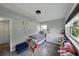 Bedroom with natural light, gray walls, tile floors, dresser, toys, and neutral paint at 1140 W Seminole Trl, Bartow, FL 33830